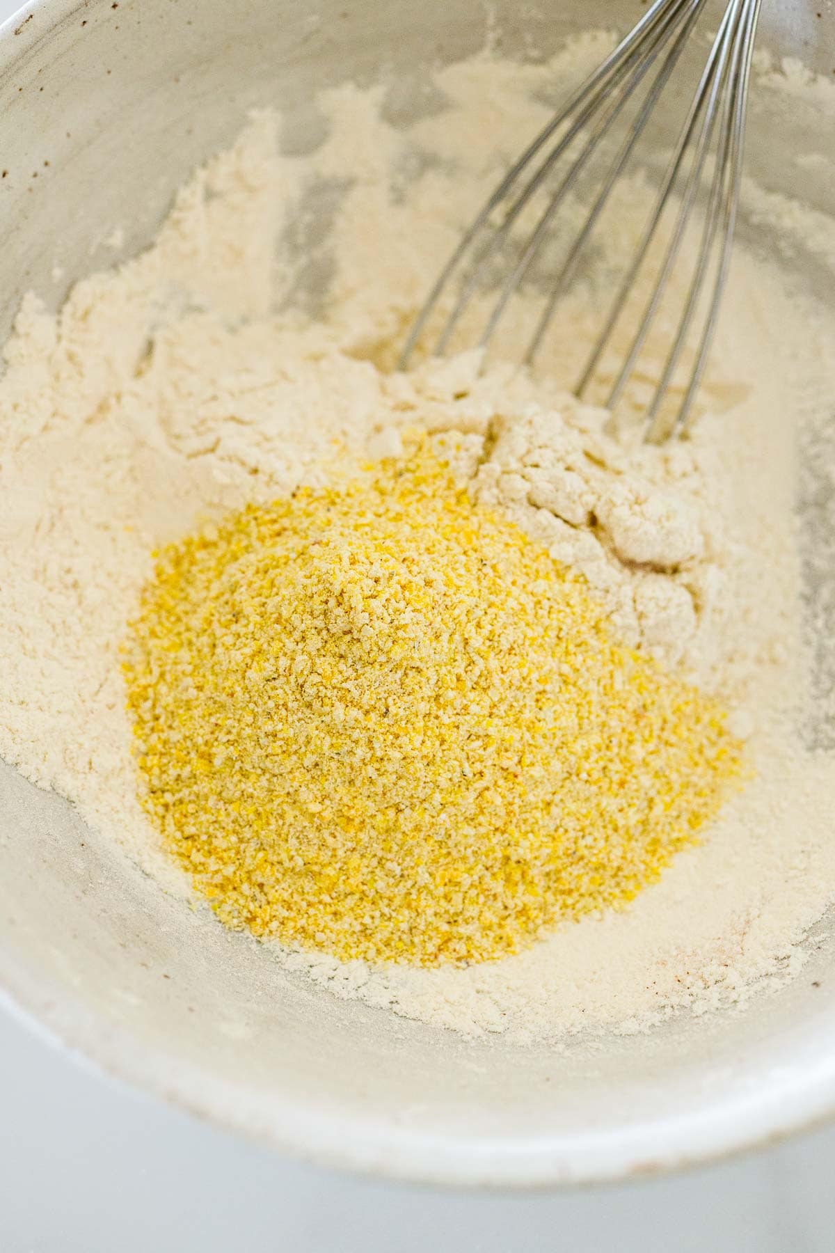 large mixing bowl with flour and cornmeal and whisk.