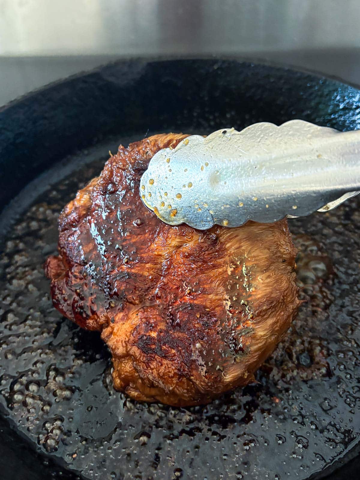 Coating the cook lion's mane steak in a soy glaze.