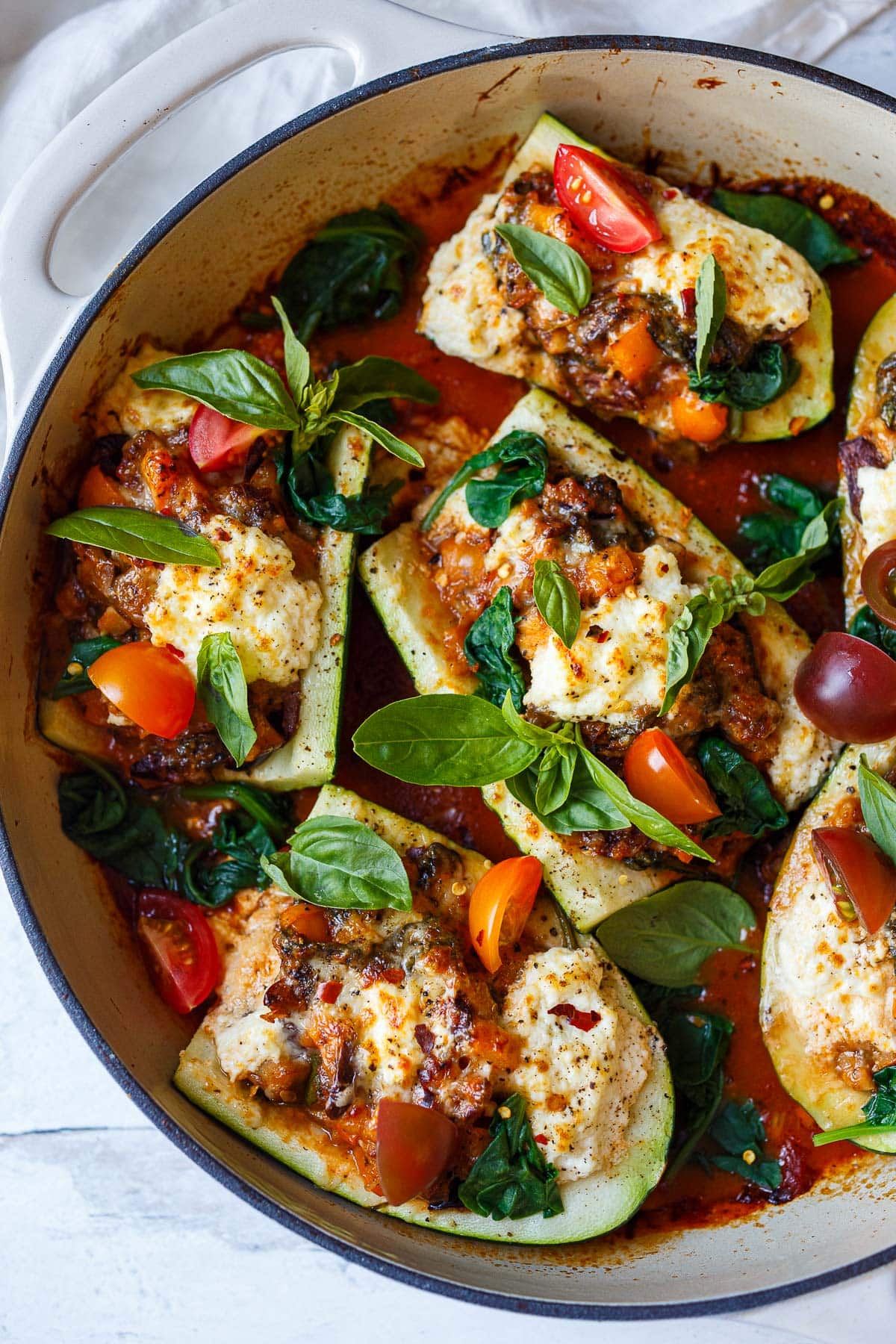 Tender zucchini is stuffed with a savory vegetarian filling of mushrooms, bell pepper, olives and spinach, topped with ricotta & baked in a marinara sauce.